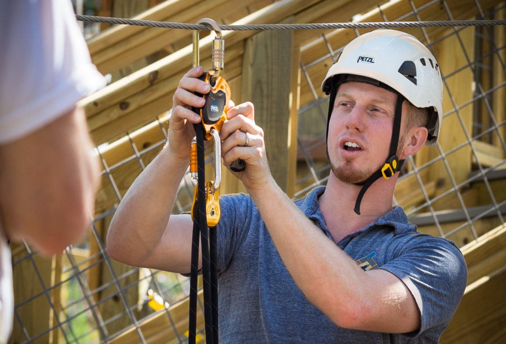Man demonstrating how to use a belay system.