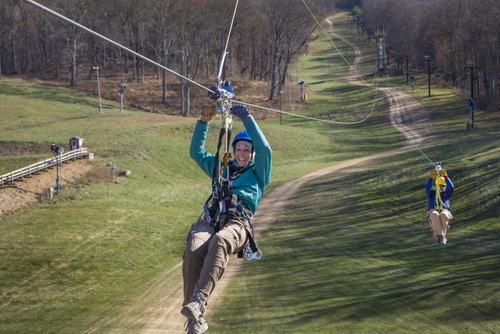 Smiling person zip lining.