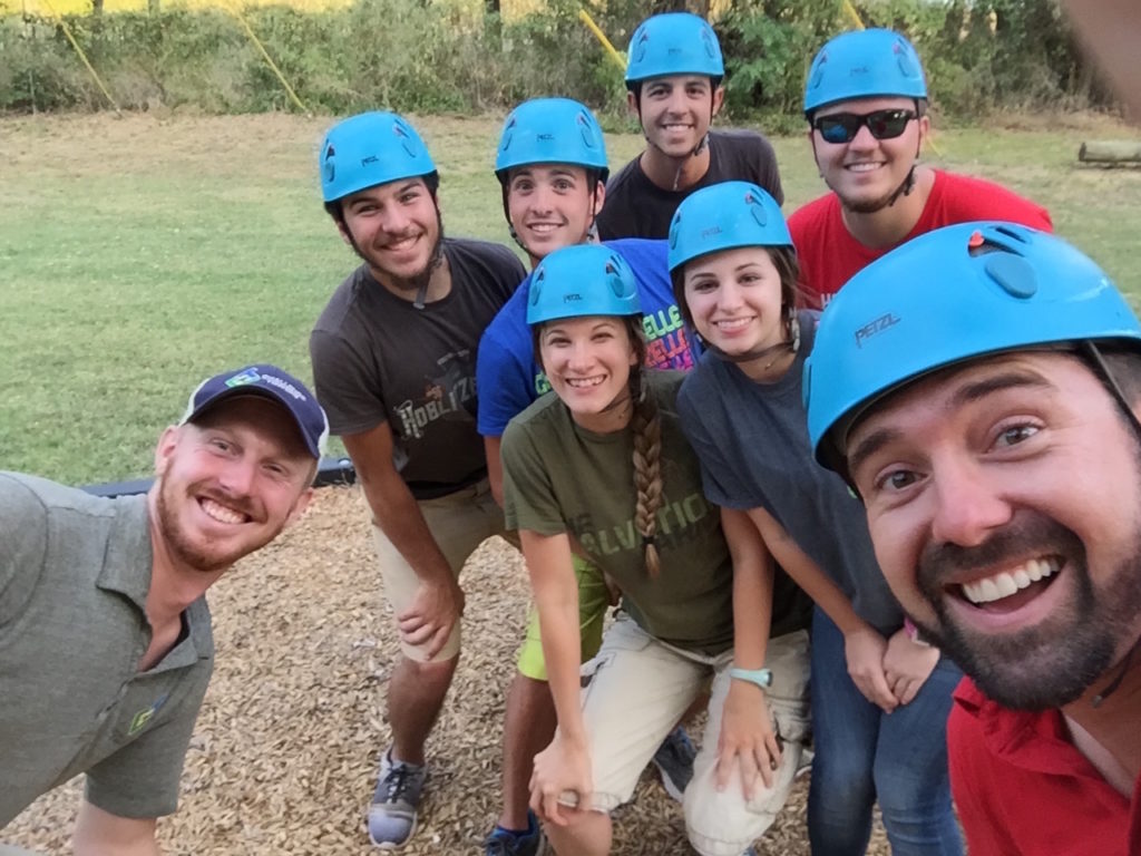 Group of smiling people wearing helmets.