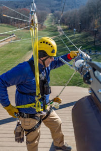 Man performing maintenance on zip line course