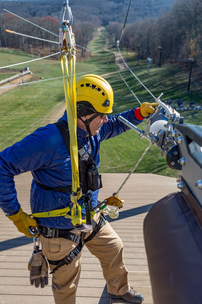 Man performing maintenance on zip line course