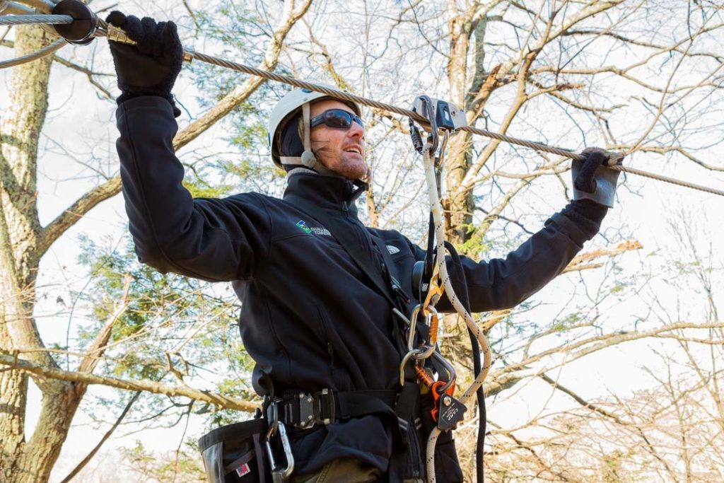 Man checking zip line on course