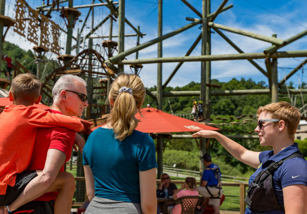 Aerial Park operator showing a family of guests around the aerial park