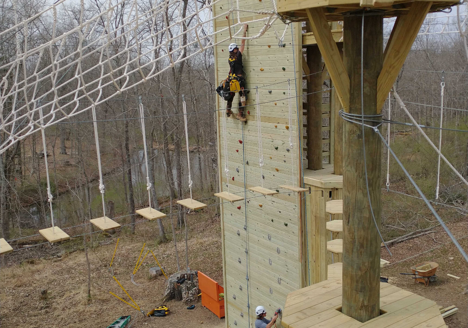 Builders put the final touches on the climbing wall at the Camp Ernst Double Discovery Challenge Course.